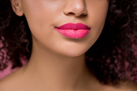 cropped view of african american girl with pink lips, isolated on pink