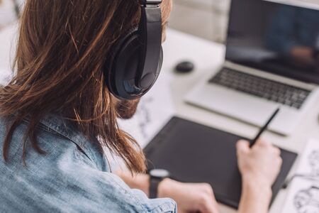 selective focus of animator listening music in headphonesの写真素材