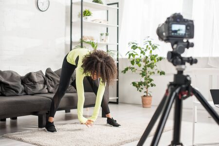 selective focus of sportive african american video blogger exercising near digital cameraの写真素材