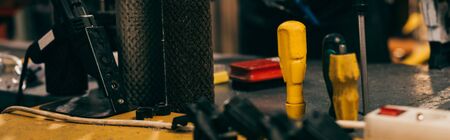 panoramic shot of screwdrivers on table in repair shop