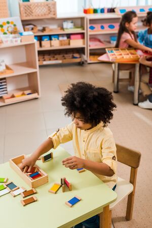 Selective focus of kid playing game with children at background in montessori schoolの写真素材