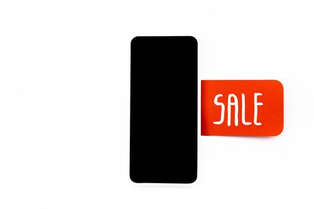 top view of smartphone with blank screen with red price tag with sale lettering isolated on white