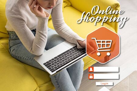 Cropped view of girl using laptop on couch at home, online shopping conceptの写真素材