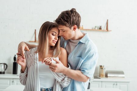 handsome man holding hands with attractive girlfriend at home