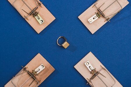 Top view of jewelry ring with mouse traps on blue surfaceの写真素材