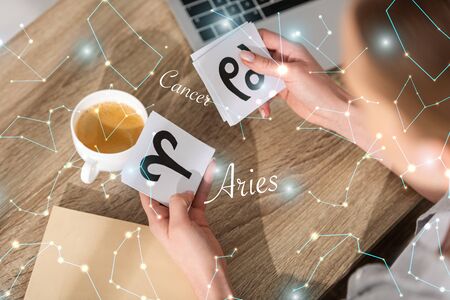 Overhead view of woman holding cards with zodiac signs near constellationsの写真素材