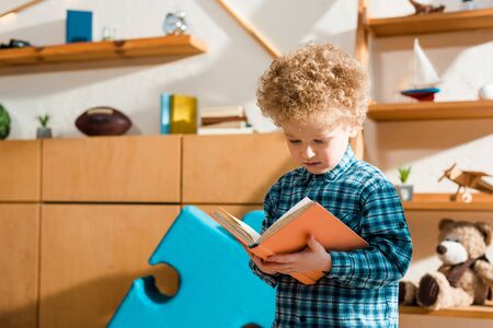 adorable and smart child reading book at home