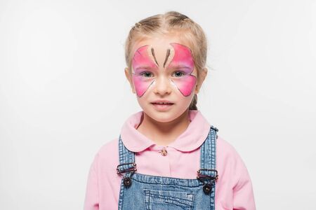 pensive child with butterfly painting on face looking at camera isolated on white
