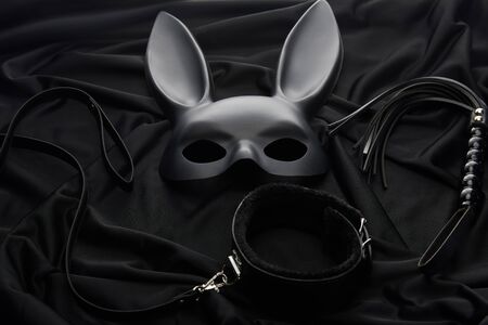 rabbit mask and sex toys on black textile backgroundの写真素材