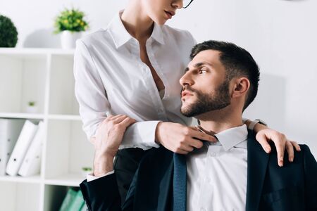 cropped view of secretary with big breast hugging handsome businessman in officeの写真素材