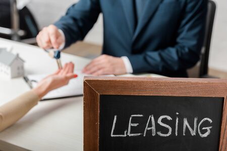 selective focus of leasing lettering on chalkboard near realtor and clientの写真素材