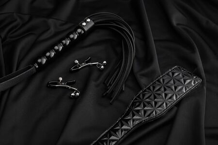 leather and metal sex toys on black textile backgroundの写真素材