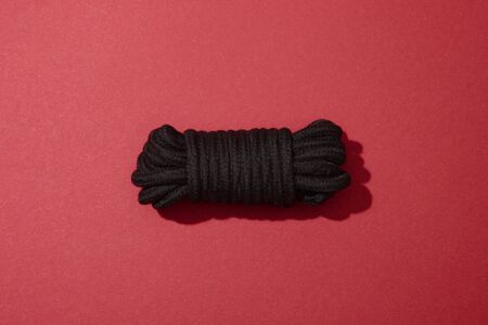 top view of black rope on red backgroundの写真素材