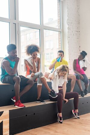 Multicultural zumba dancers resting while training in dance studio