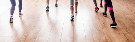 Cropped view of multicultural dancers performing zumba in dance studio, panoramic shotの写真素材