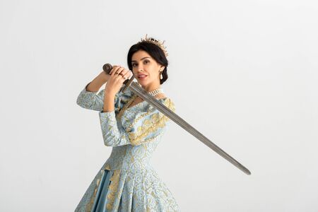 smiling queen with crown holding sword isolated on greyの写真素材