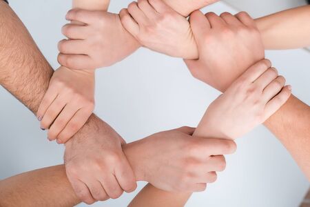 top view of women and man with joined hands together on white, human rights concept