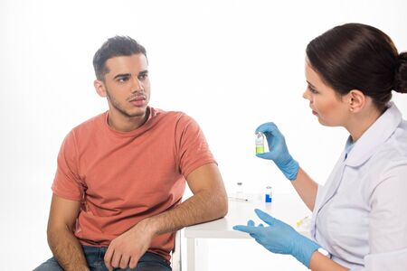 Female doctor showing hpv vaccine to patient at table isolated on white