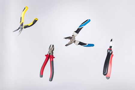 Metal pliers levitating in air isolated on greyの写真素材