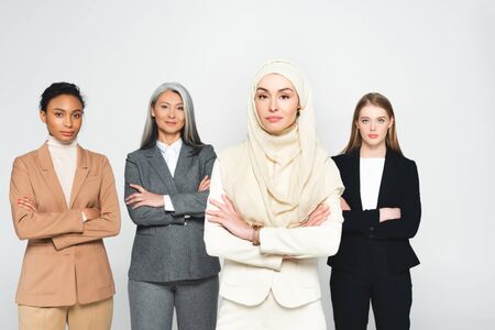 beautiful multicultural businesswomen standing with crossed arms isolated on whiteの写真素材