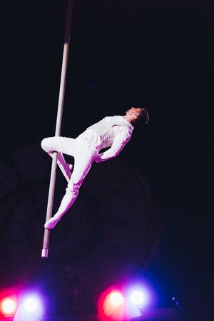 KYIV, UKRAINE - NOVEMBER 1, 2019: Handsome air gymnast with pole performing in circus isolated on blackのeditorial素材