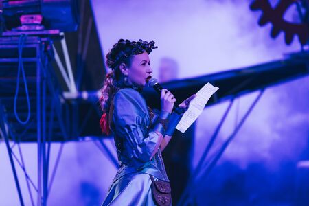KYIV, UKRAINE - NOVEMBER 1, 2019: Side view of attractive artist with microphone performing at circusのeditorial素材