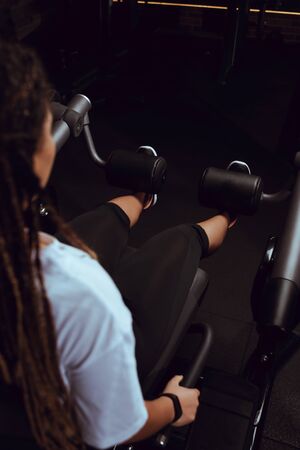 Cropped view of african american woman doing exercise for abs in gym
