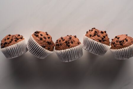 top view of fresh chocolate muffins on marble surface
