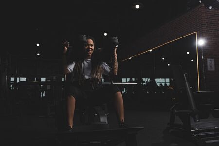 tattooed african american girl working out on gym machineの写真素材