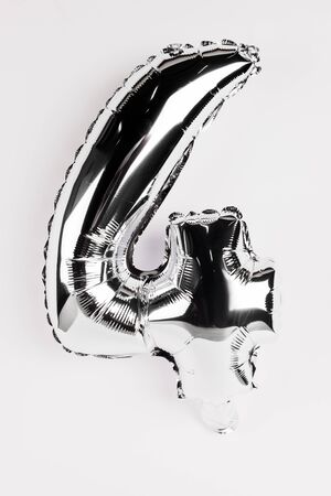 Festive silver balloon in shape of four number on grey backgroundの写真素材