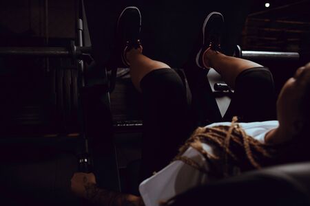 selective focus of tattooed african american girl working out on fitness machineの写真素材