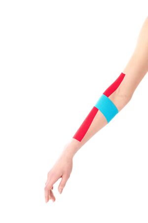 Cropped view of kinesiology tapes on woman hand isolated on whiteの写真素材