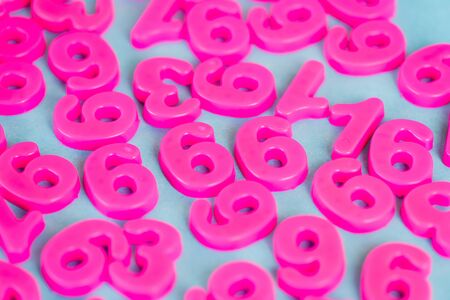 High angle view of pink plastic numbers on blue surface
