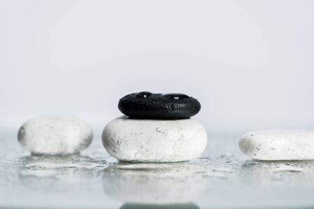 Back and white zen stones with water drops on wet glass on grey backgroundの写真素材