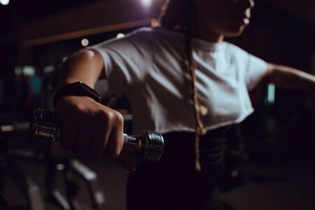Selective focus of african american woman holding dumbbellの写真素材