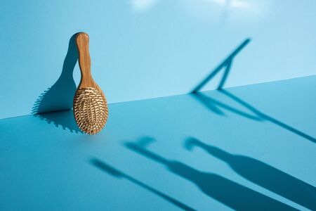 Hair brush and shadows on blue background, zero waste conceptの写真素材