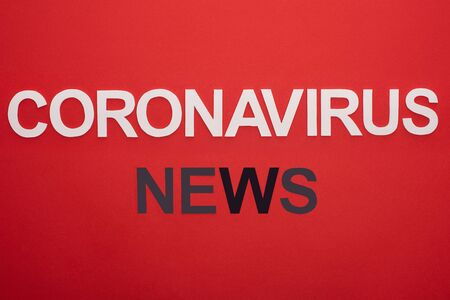 Top view of coronavirus news lettering isolated on redの写真素材