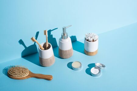 Jars of wax and tooth powder, hair brush, dispenser and toothbrush holders with toothbrushes, ear...