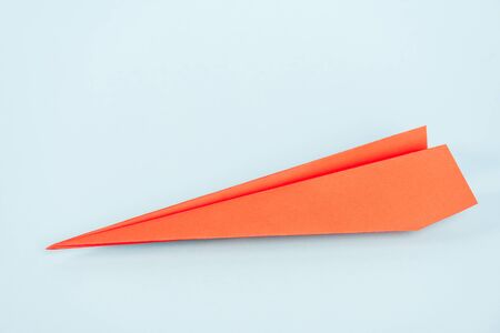 orange paper plane on blue with copy spaceの写真素材