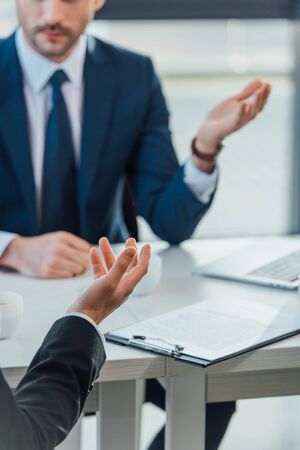 cropped view of businessmen talking on meeting in modern officeの写真素材