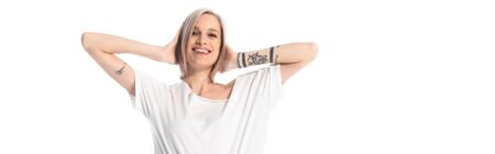 happy young tattooed girl with hands on head isolated on white, panoramic shot