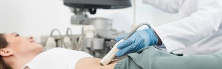 panoramic shot of doctor making ultrasound scan of stomach in clinic