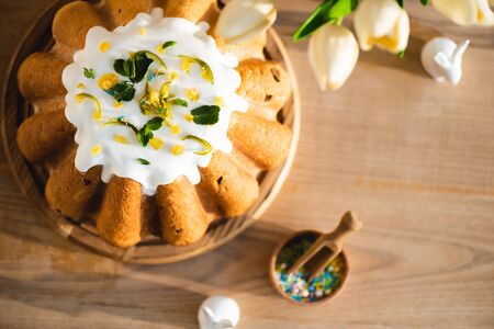 top view of tasty easter cake near figurines with decorative easter bunnies and tulips