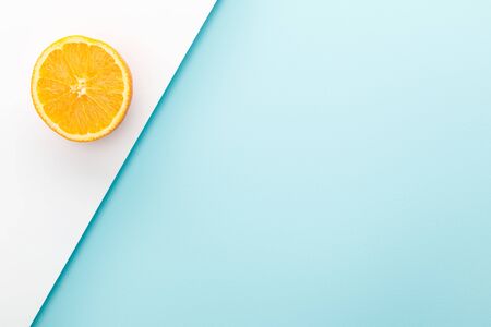 Top view of orange half on white and blue background