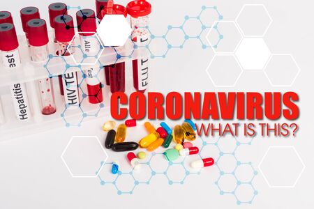 test tubes with blood samples near pills and coronavirus what is this lettering on whiteの写真素材