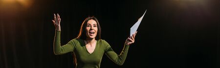 panoramic shot of attractive emotional actress performing role on black