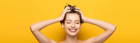 panoramic shot of girl with closed eyes washing hair on yellow background