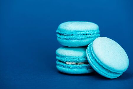 tasty french macaroons on blue background with copy spaceの写真素材
