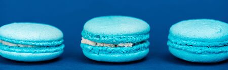 panoramic shot of french macaroons on blue background