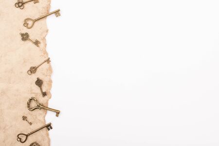 top view of vintage keys on aged paper isolated on whiteの写真素材